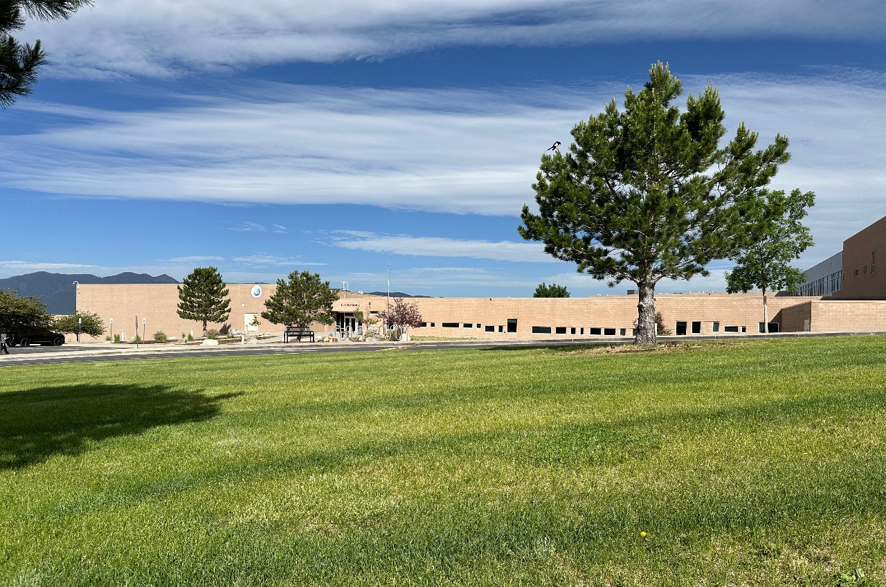 The DCCMS building surrounded by grass and trees.